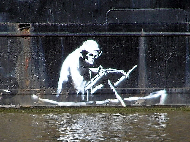 Stencil on the waterline of The Thekla, an entertainment boat in central Bristol – (wider view). The section of the hull with this picture has now been removed and is on display at the M Shed museum. The image of Death is based on a nineteenth-century etching illustrating the pestilence of The Great Stink.[19] Artist: Banksy - Photographed by Adrian Pingstone