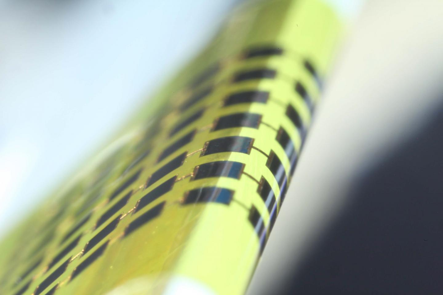 Caption: Ultra-thin solar cells are flexible enough to bend around small objects, such as the 1mm-thick edge of a glass slide, as shown here. Credit: Juho Kim, et al/ APL